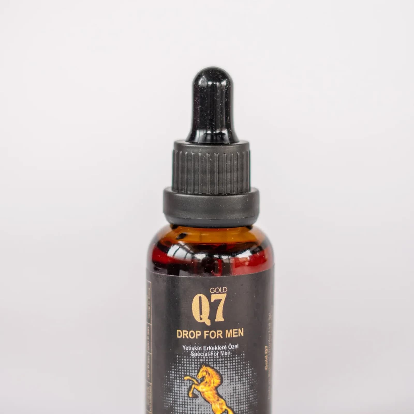 Q7 Gold drops for men, natural strength. Angled view, showing bottle and dropper.